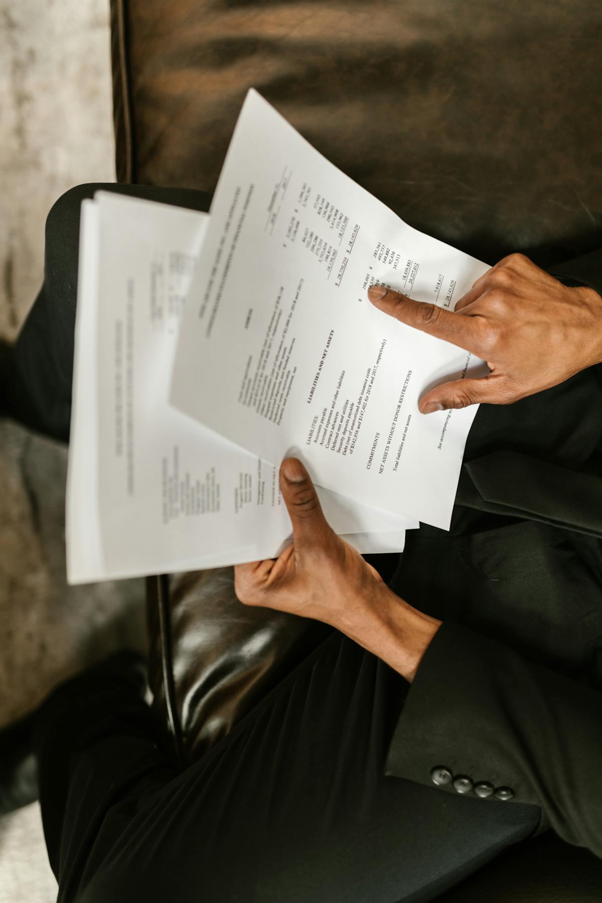 Person reviewing a printed financial balance on a table